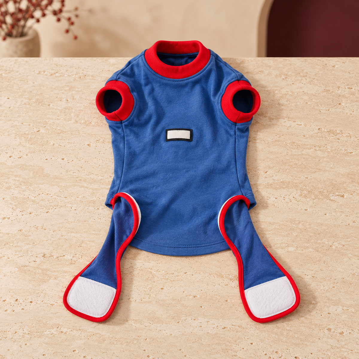 Blue recovery suit with red-bound openings and rear fastening panels